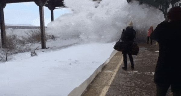 Поезд окатил волной снега людей на перроне